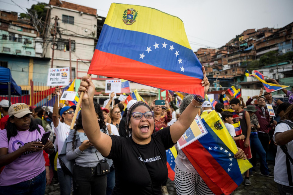 Una persona sostiene una bandera de Venezuela en una manifestación este viernes, en Caracas (Venezuela). Simpatizantes del chavismo se movilizaron en comunidades de Venezuela para participar en la jornada de alistamiento de milicianos y reiterar su respaldo al presidente Nicolás Maduro ante lo que consideran "amenazas" de Estados Unidos