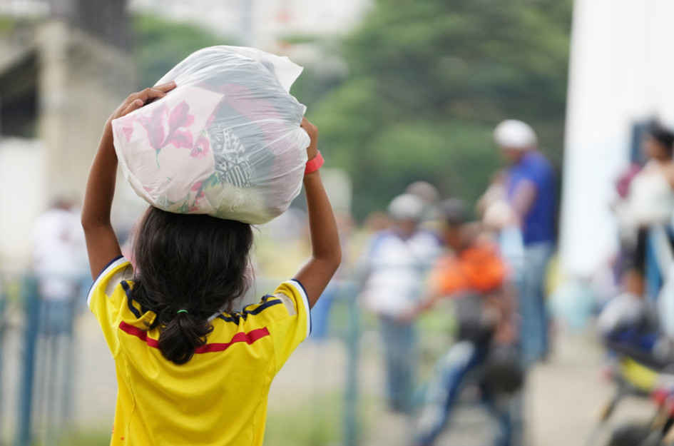 Fotografía de archivo fechada el 23 de julio de 2025 de una niña víctima de desplazamiento sosteniendo una bolsa con pertenencias en Jamundí (Colombia).