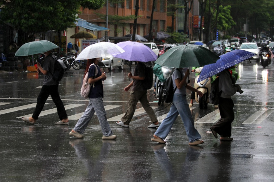 Personas con paraguas caminan bajo la lluvia en Hanoi (Vietnam).