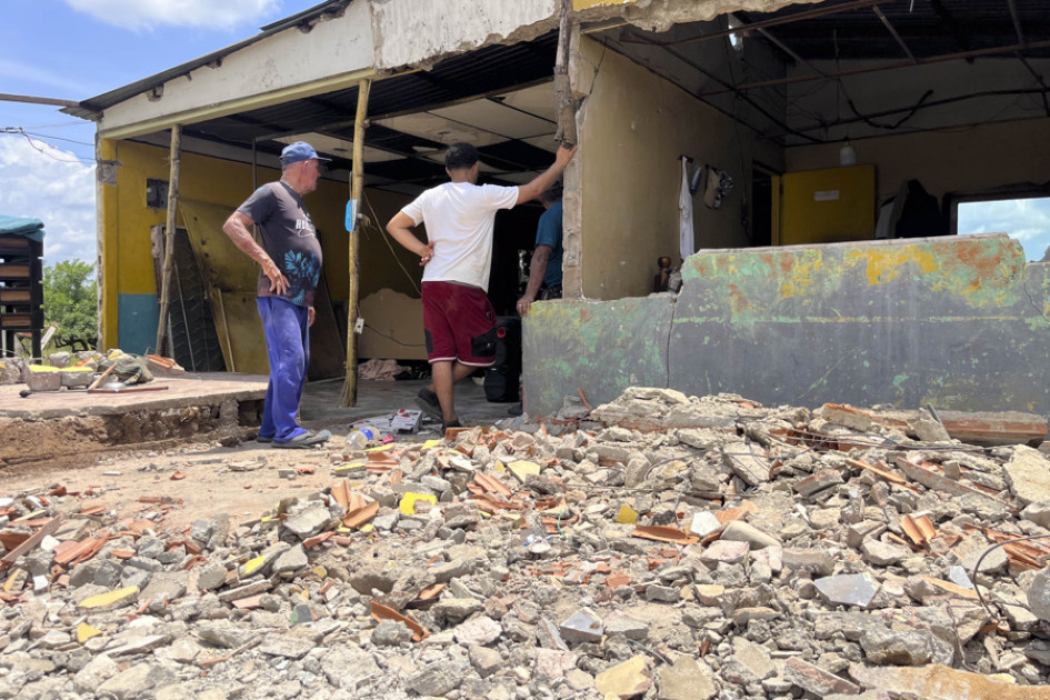Personas observan una casa afectada por un sismo, este viernes en Mene Grande (Venezuela).