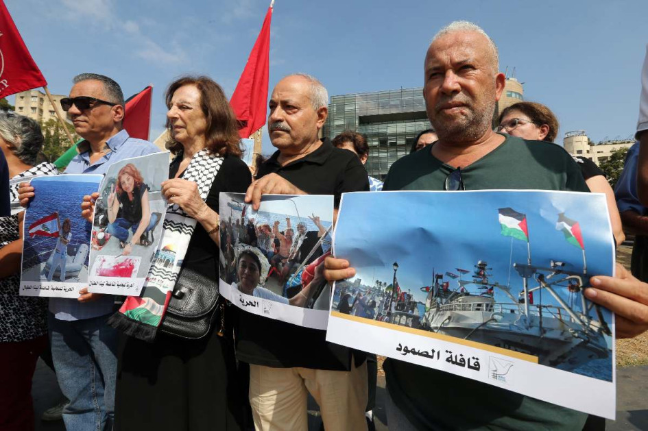Activistas portan fotografías de dos de los activistas libaneses detenidos, Lina Tabbal y el libanés-brasileño Mohammed Al Kadri, durante una protesta. 