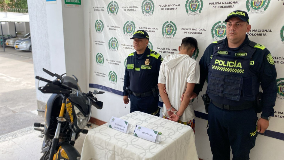 La moto recuperada y la persona que terminó detenida.