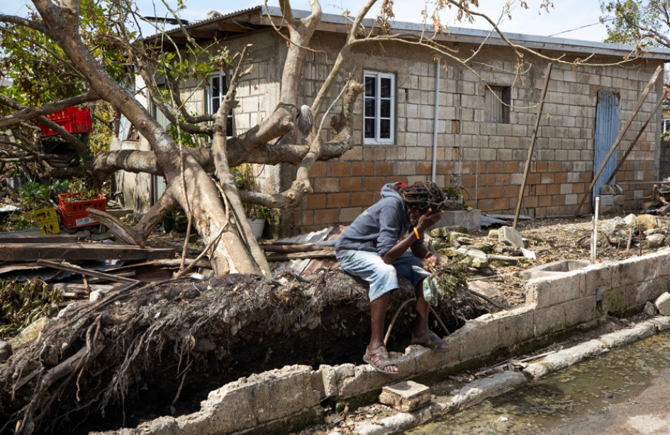 Un hombre descansa frente a una casa llena de escombros tras el paso del huracán Melissa este lunes, en Falmouth (Jamaica).