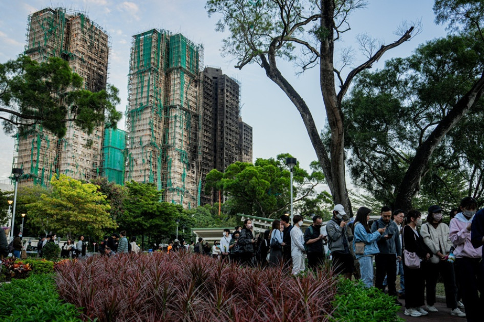 La gente deposita ofrendas florales para las víctimas del incendio en el complejo residencial Wang Fuk Court en el distrito Tai Po de Hong Kong, China, el 29 de noviembre de 2025.