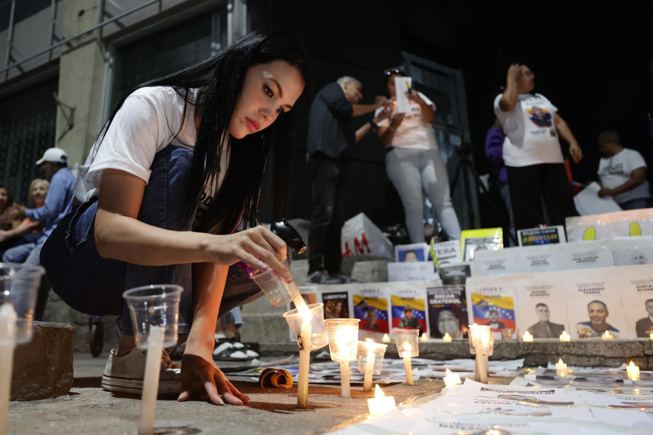 Una persona enciende una vela frente al Helicoide en Caracas (Venezuela). Los excarcelados en ese país son 626, según la presidenta encargada, Delcy Rodríguez.