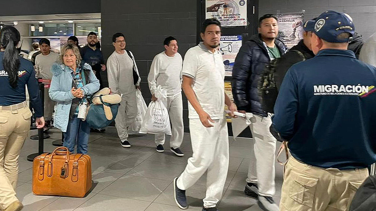 Funcionarios de Migración Colombia recibieron a ciudadanos colombianos a su llegada este viernes al aeropuerto El Dorado en Bogotá.