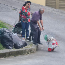 Dos adultos mayores con una niña tuvieron que bajar del anden para poder continuar con su camino debido a la basura que había en esa esquina.